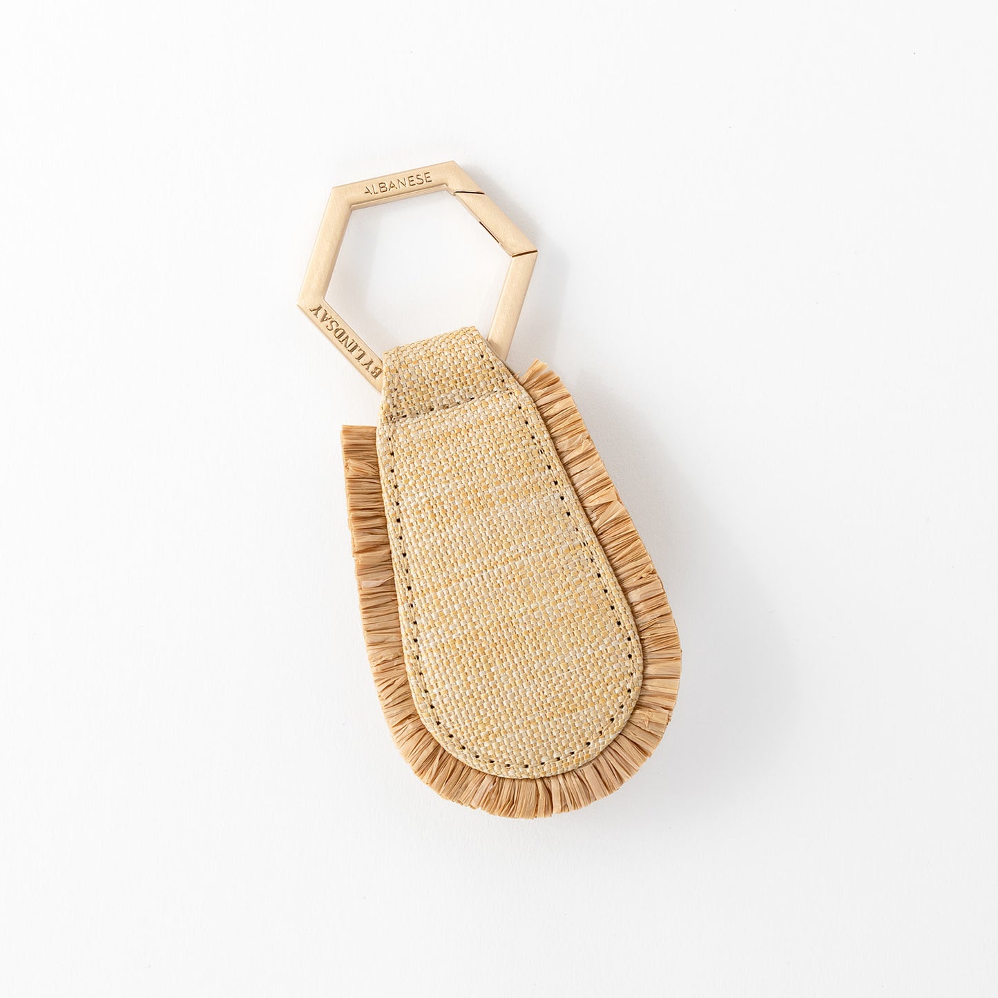 A beige raffia hat clip with a frayed edge design, displayed against a white background.