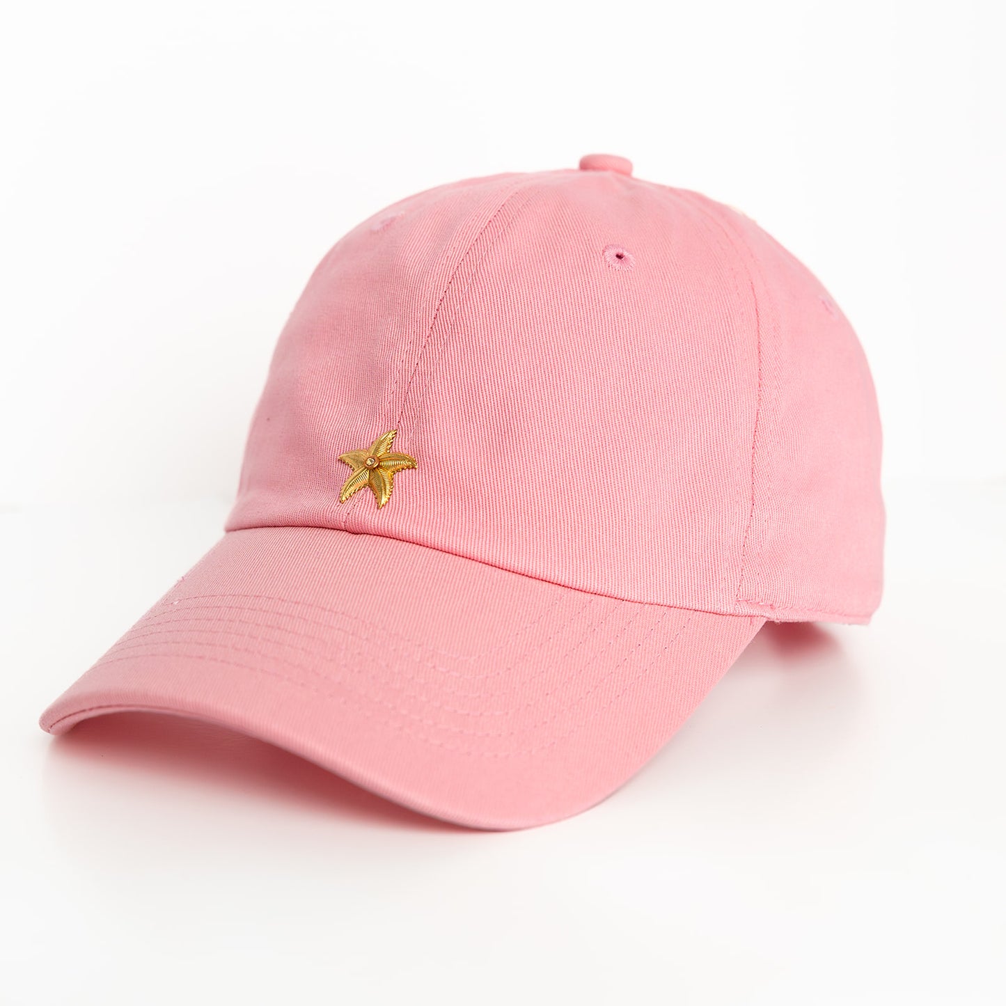 A pink baseball hat with a gold starfish emblem detail on the front.