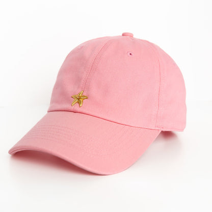 A pink baseball hat with a gold starfish emblem detail on the front.