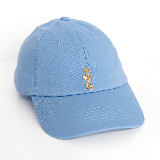 A blue baseball hatwith a gold sea horse emblem detail on the front.