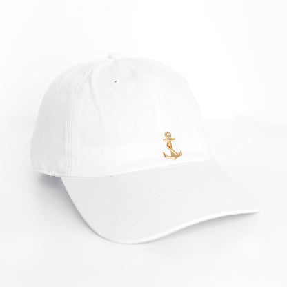 A white baseball cap with a gold anchor emblem on the front.