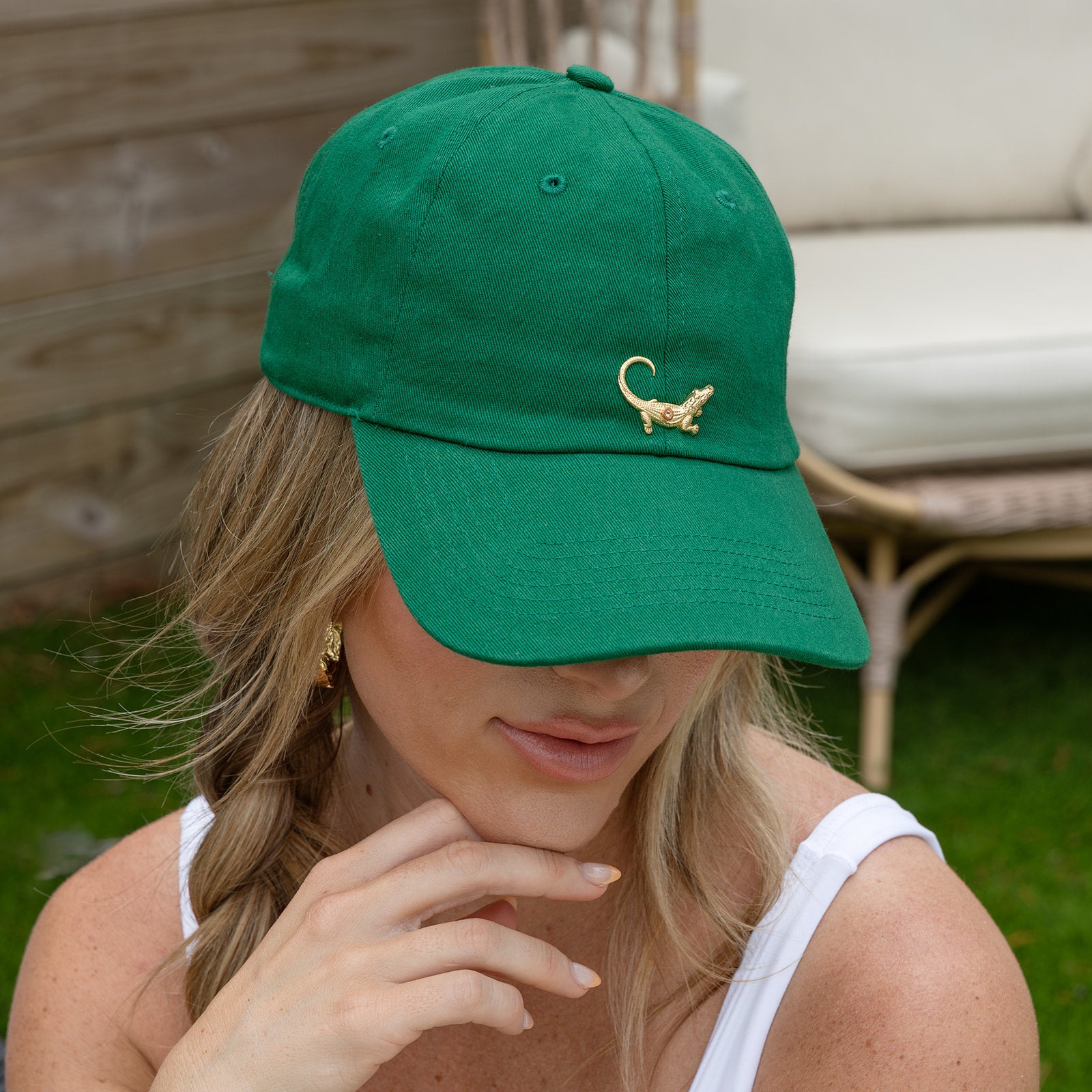 Woman wearing a green hat with a golden gator emblem.